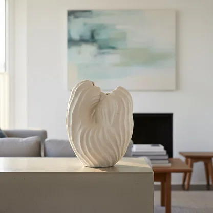 White ceramic sculpted leaf design vase displayed on console table creating elegant and contemporary interior decor accent.