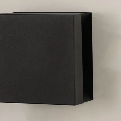 Closeup view of matte black metal finish and clean geometric lines of the modern square outdoor wall lighting fixture design.