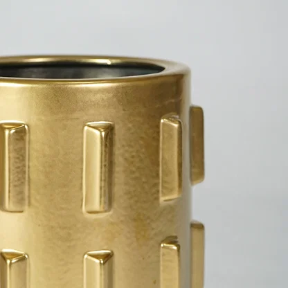 Closeup image of gold metal decor vase for luxury console table styling with modern textured finish display.