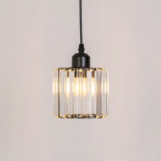 Clear ribbed glass pendant light with warm glow and black frame adding elegant ambient lighting for interiors.