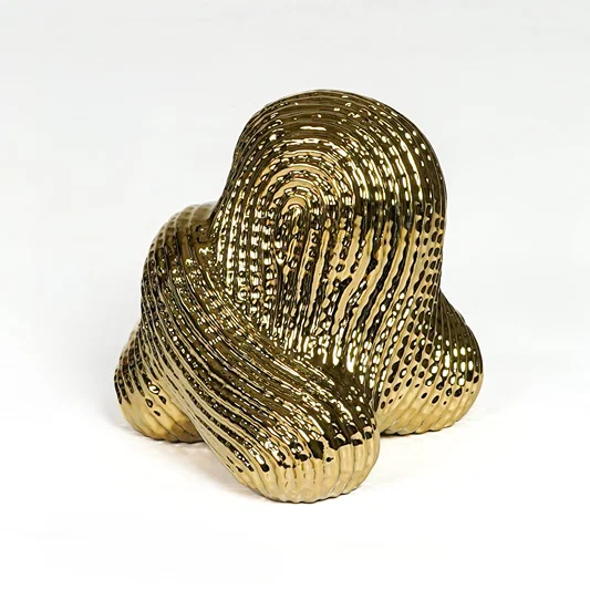 Contemporary gold metal statement decor sculpture with sculpted pattern for luxury interiors.
