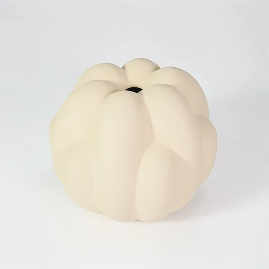 Cream sculptural ceramic vase for stylish coffee table placement and minimalist indoor decor styling accent piece.