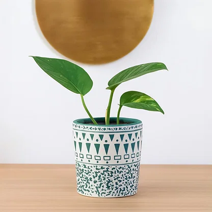A decorative ceramic planter with teal and white patterns styled in a soft setting showing its artistic detailing for a modern home decor look.