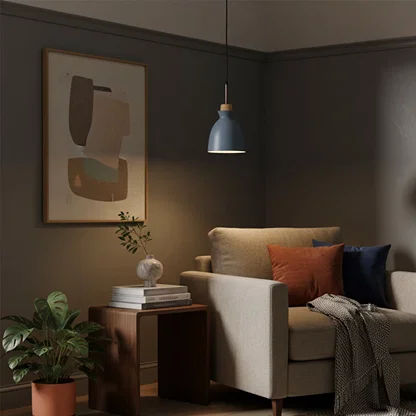 Blue metal pendant light above side table adding Scandinavian elegance and warm ambient lighting to modern living rooms.