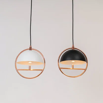 Set of black and white metal pendant lights with copper finish for stylish contemporary interiors.
