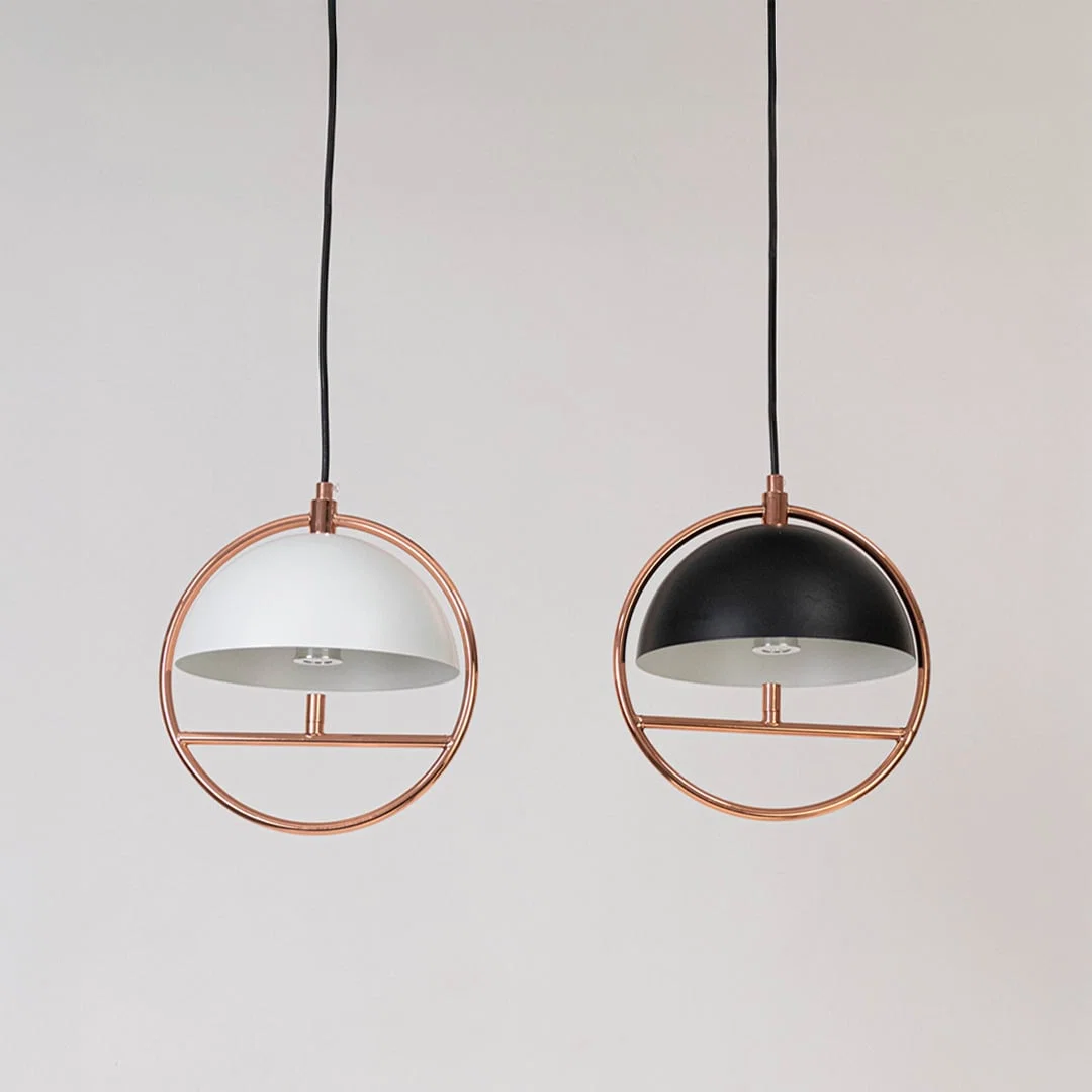 Set of black and white metal pendant lights with copper accents for stylish modern home decor.