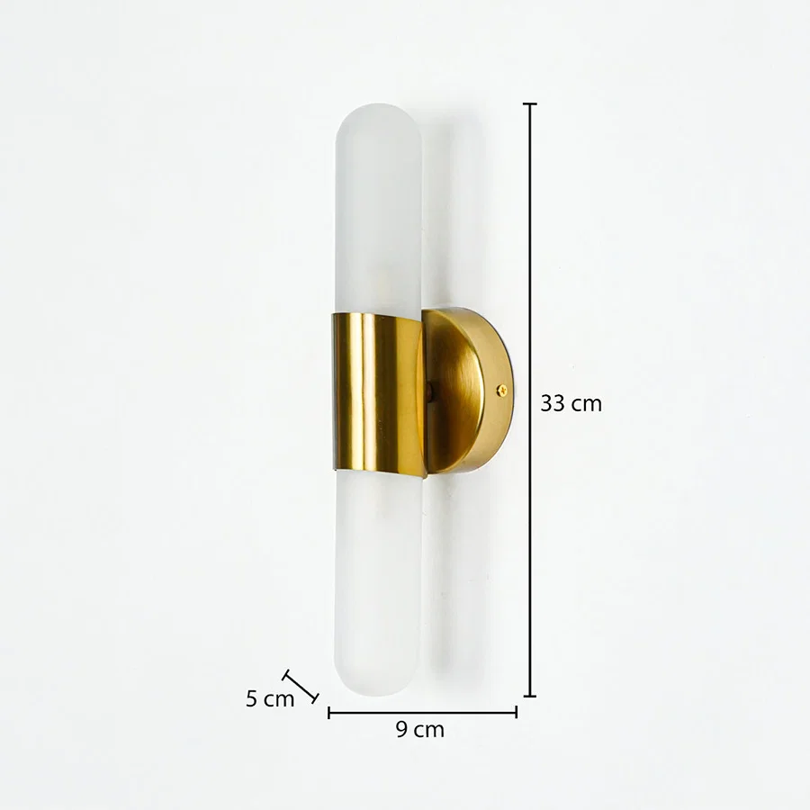 Modern wall light with frosted cylindrical glass and gold metal base mounted on neutral wall background 33 cm height 9 cm width 5 cm depth ideal for contemporary interior lighting.