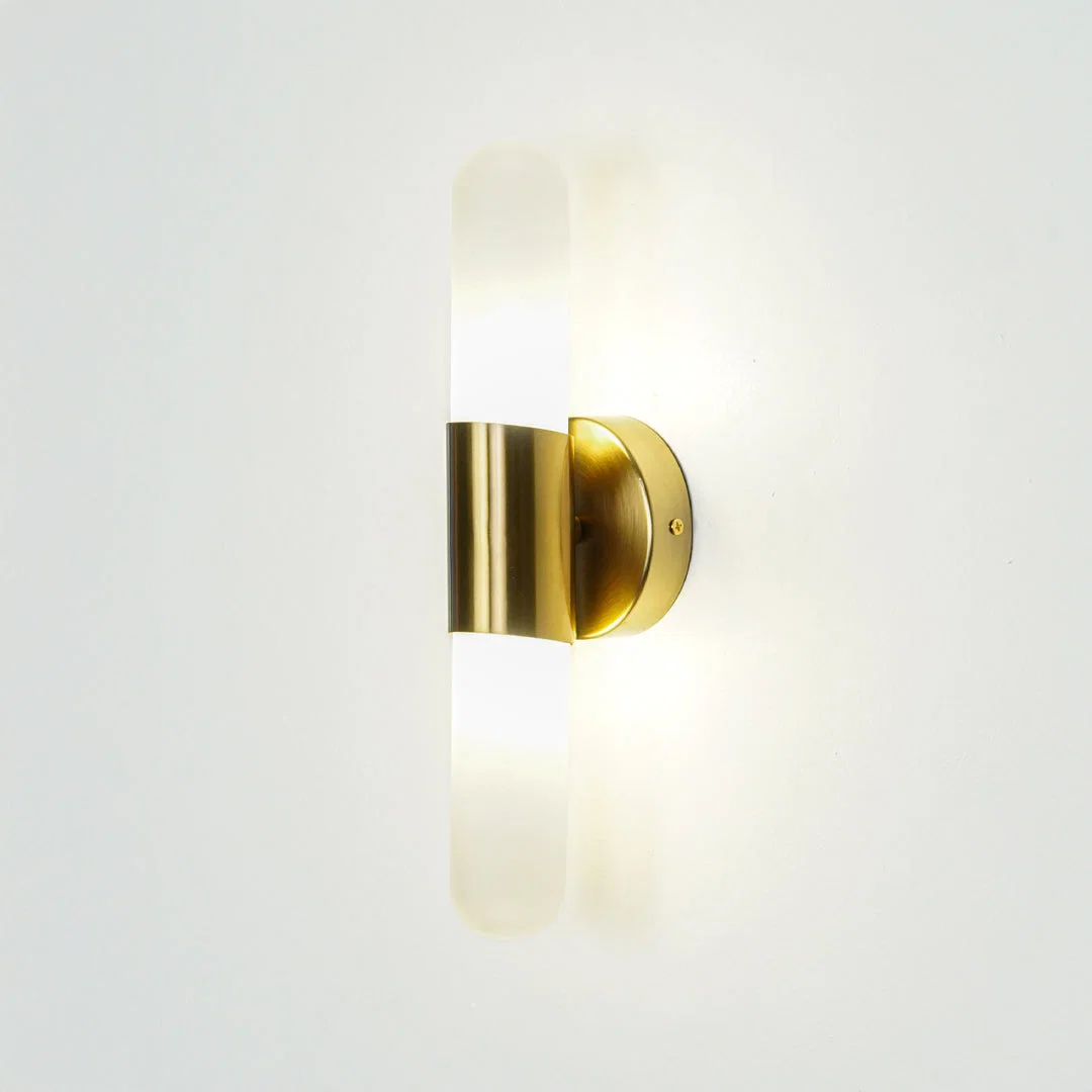 Gold wall light with vertical frosted glass tube mounted on neutral wall background ideal for modern bedroom or hallway lighting.