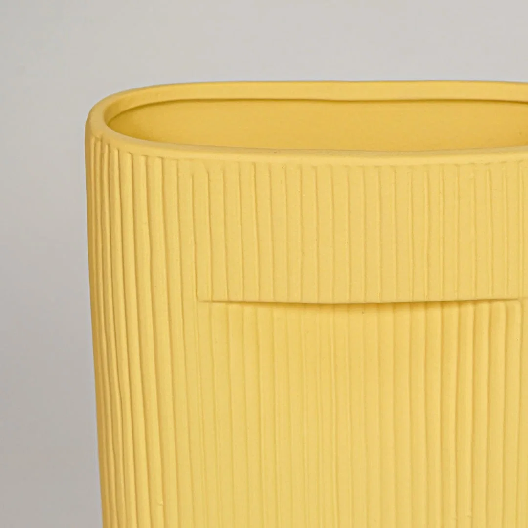 Closeup of mustard ceramic vase with ribbed textured finish for elegant shelf and tabletop decor styling ideas.