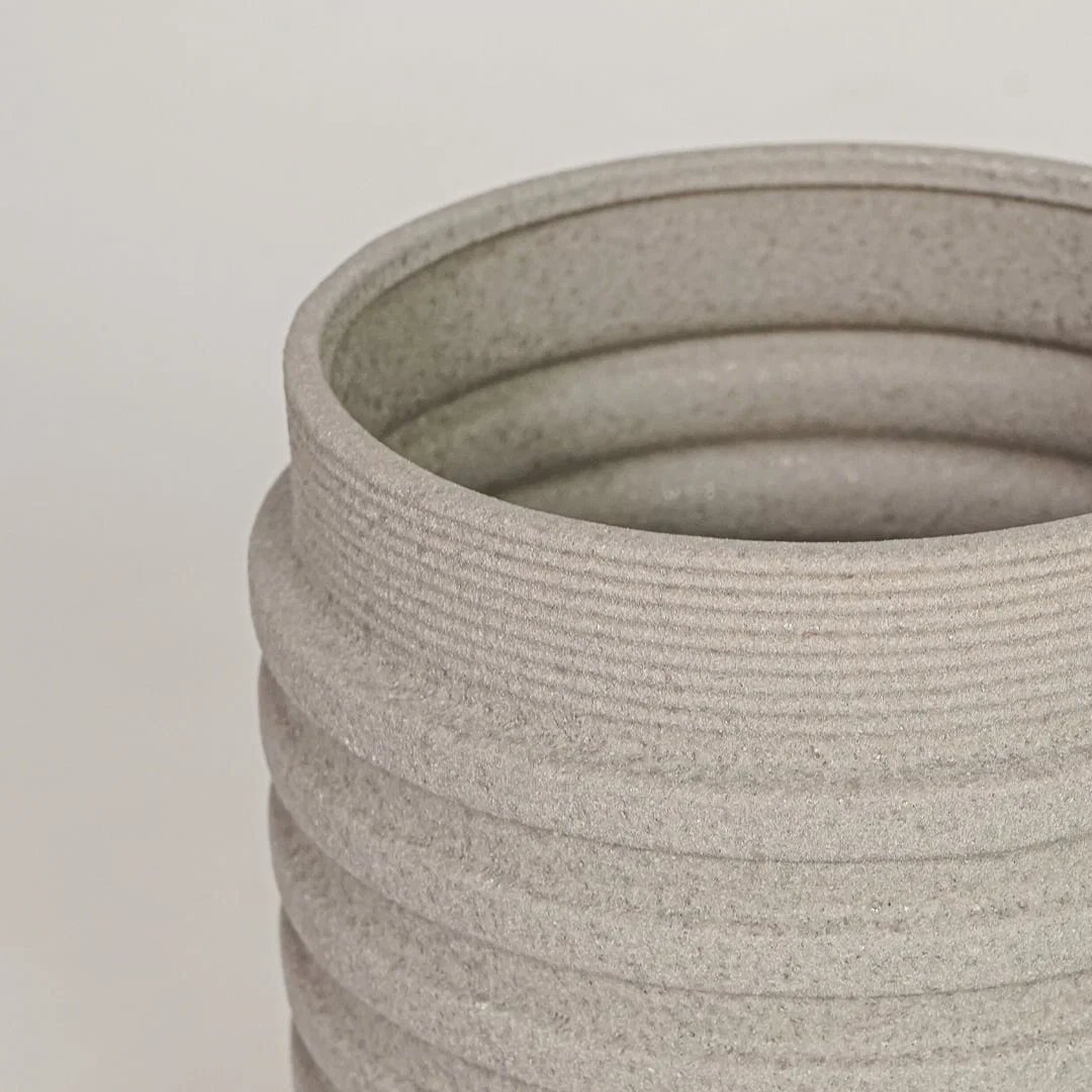 Closeup of beige ceramic vase with ribbed textured finish for elegant tabletop and shelf decor styling ideas.