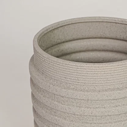 Closeup of beige ceramic vase with ribbed textured finish for elegant tabletop and shelf decor styling ideas.