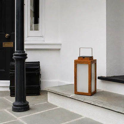 Modern copper metal outdoor lantern with frosted glass panels enhancing front porch decor with warm ambient lighting.