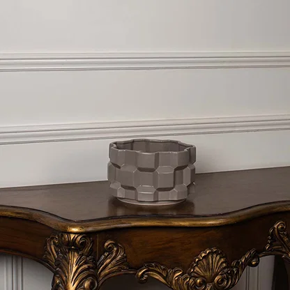 Taupe geometric ceramic planter displayed on a clean white background showing its shape and detailing clearly.