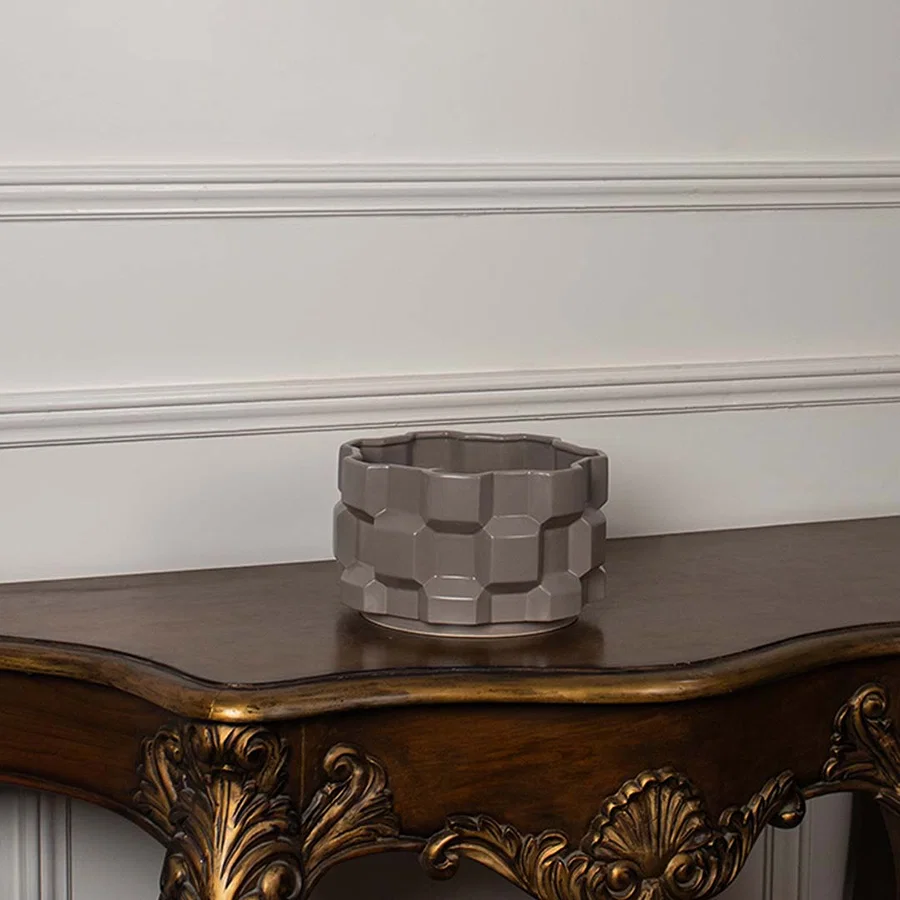 Taupe geometric ceramic planter displayed on a clean white background showing its shape and detailing clearly.