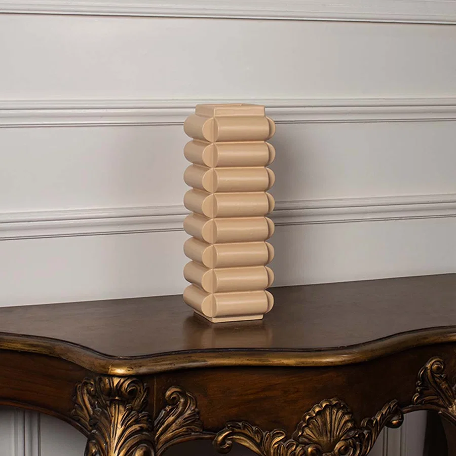 A beige geometric vase photographed on a clean white background showcasing its stacked rounded shape and contemporary decorative appeal.