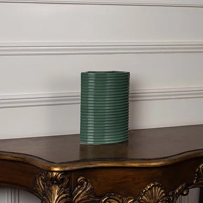 Dark green ribbed ceramic planter displayed on a clean white background ideal for sleek home decor and tabletop styling.