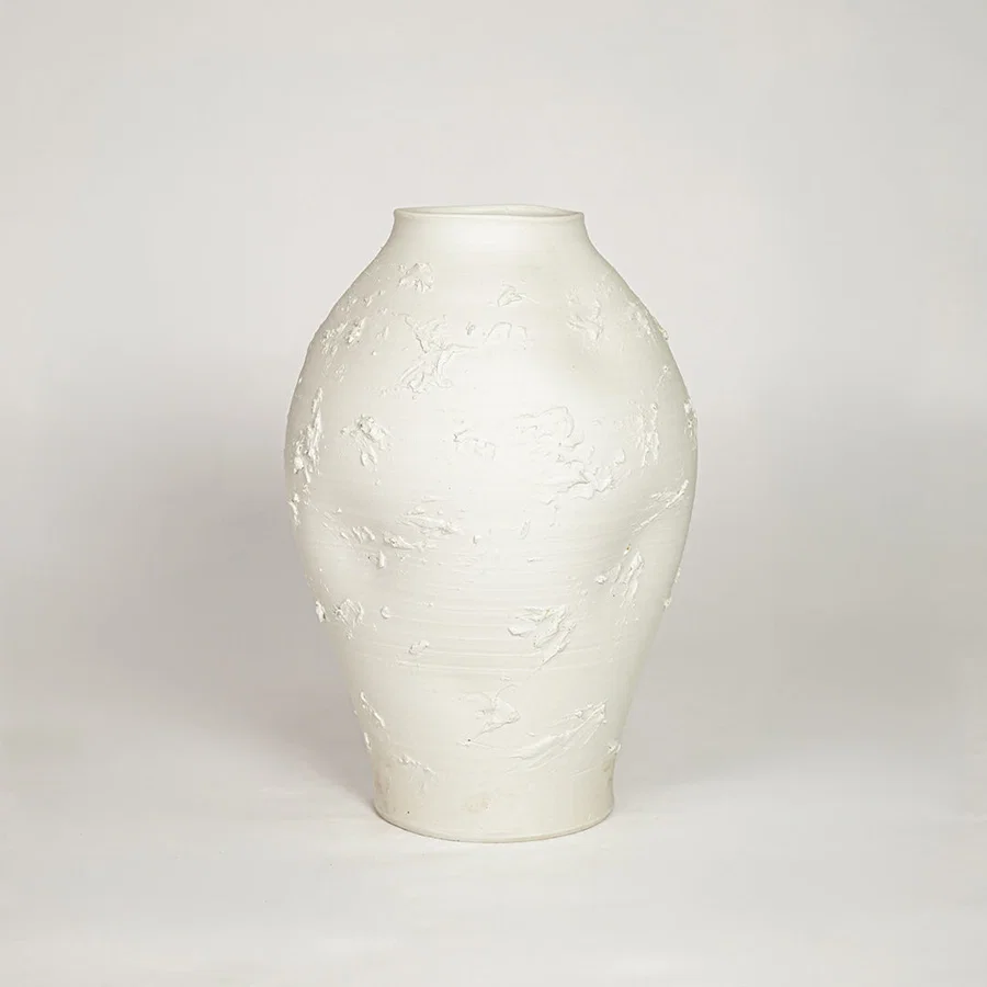 Sculptural white ceramic vase with organic shape for sophisticated modern home decor and minimalist interior style.