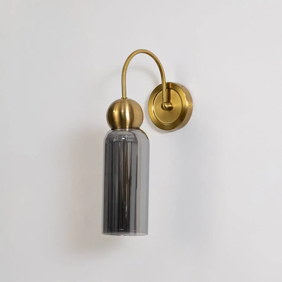 Gold metal wall light with smoked grey glass shade shown on a white background for clear product detailing.