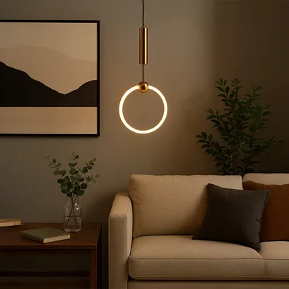 Gold metal ring pendant light creating warm ambient lighting above sofa in a modern living room setting.