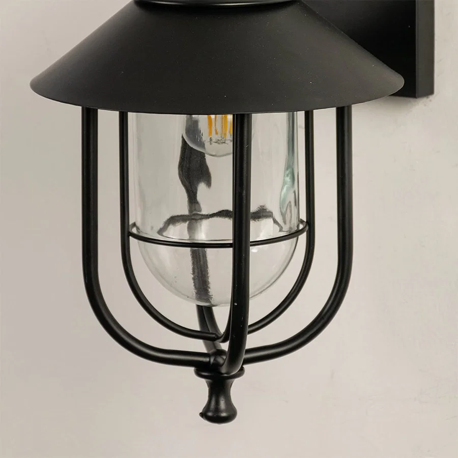 Close view of the black outdoor lantern showing detailed metal curves clear glass housing and refined modern finish.