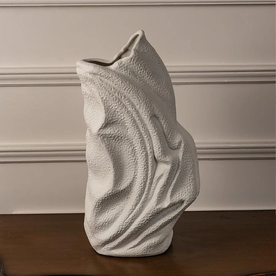 White ceramic textured vase with artistic wavy surface placed on white background for elegant modern home decor.
