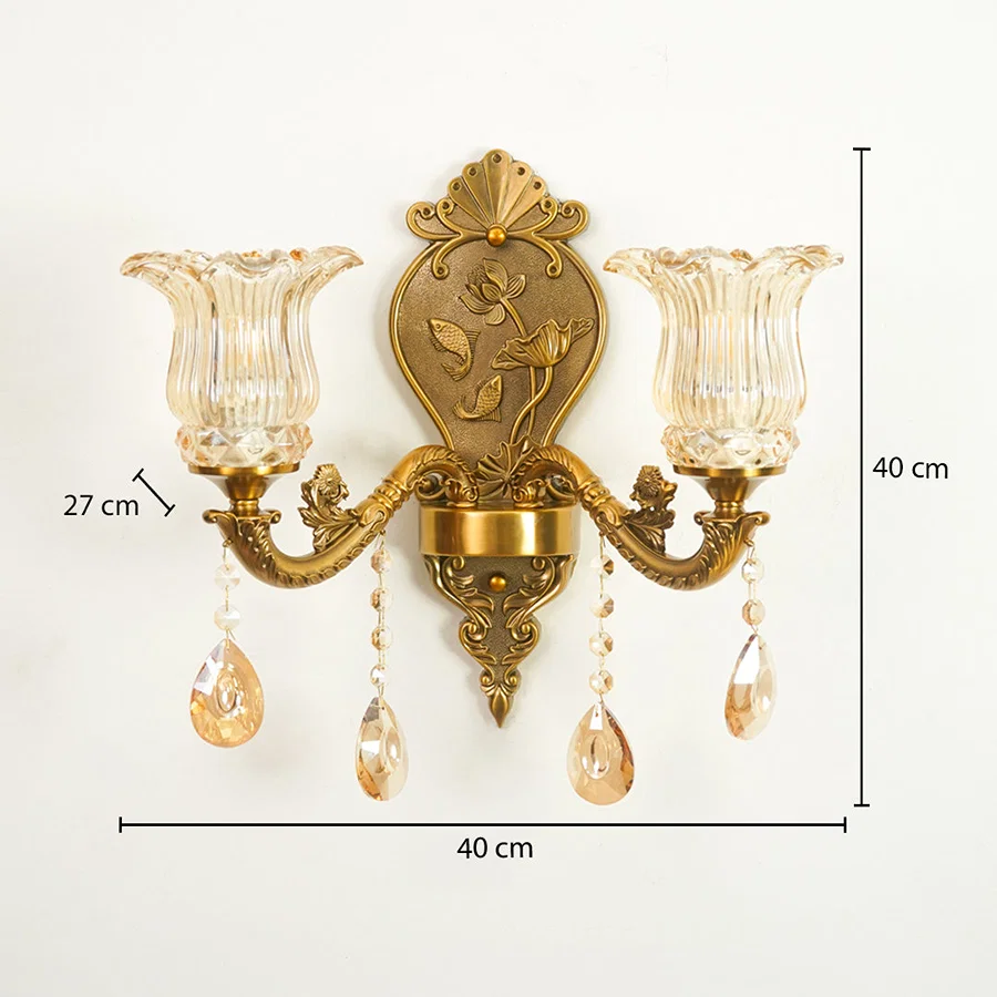 An ornate two-light wall sconce with a gold-toned metal frame, clear ribbed glass shades, and hanging crystal teardrop drops, shown with dimension labels indicating 40 cm width, 40 cm height, and 27 cm shade-to-center spacing on a white background.