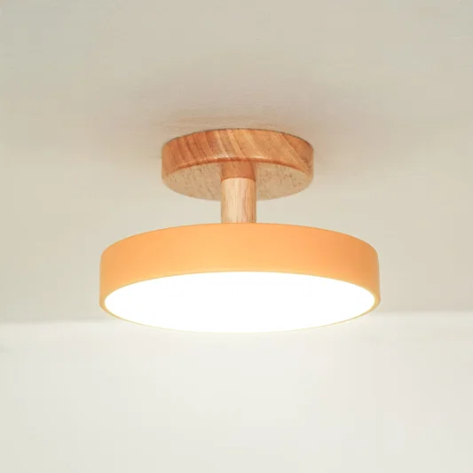 Closeup of peach metal and natural wood ceiling light for contemporary bedroom and Scandinavian decor styling spaces.
