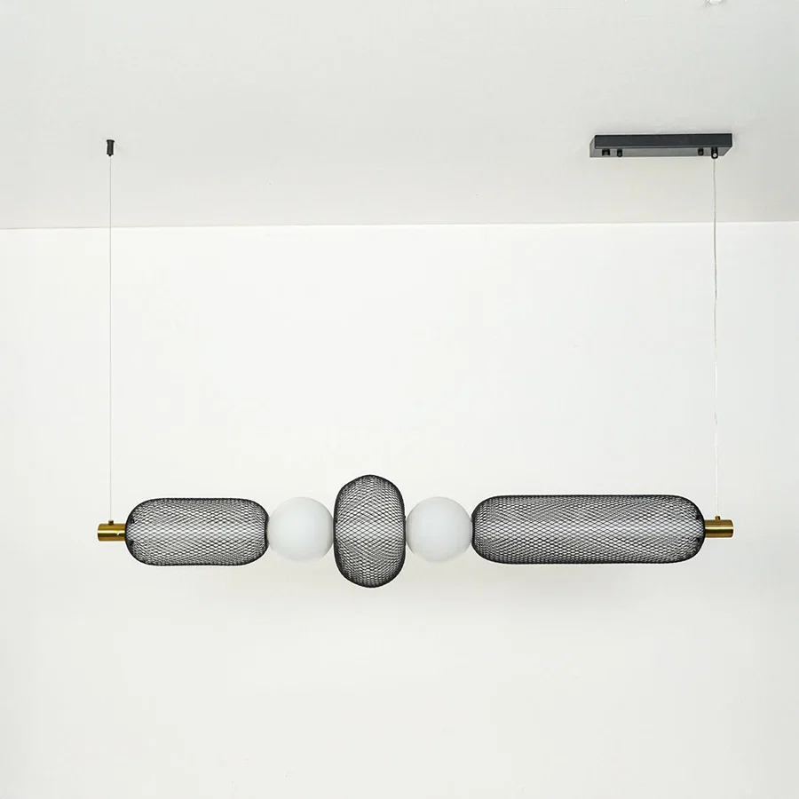 Modern wall light with textured glass cylinders and metal accents mounted on neutral wall background ideal for contemporary bathroom or hallway lighting.