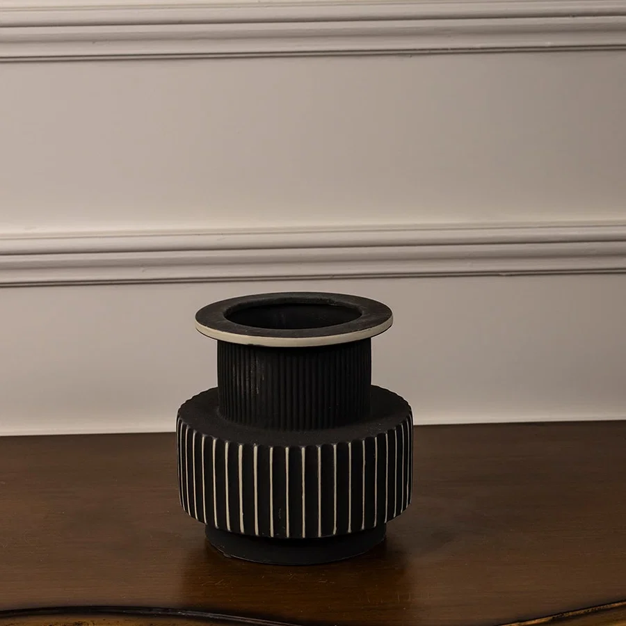 Black and white ceramic vase with ribbed surface and matte finish displayed on white background for modern home decor.