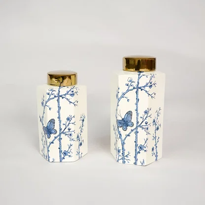 Blue and white ceramic ginger jar set with gold lid for tabletop shelf or console décor in elegant modern interiors.