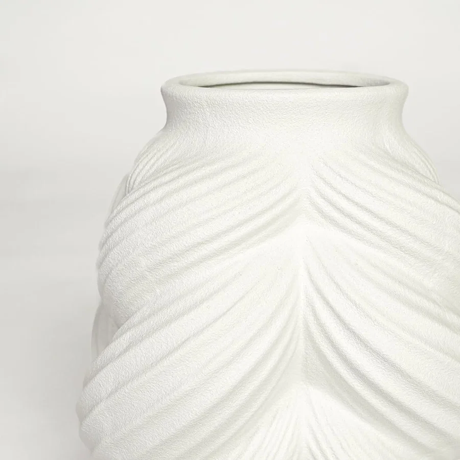 Close view of white ceramic sculpted vase highlighting layered leaf pattern and smooth matte finish.