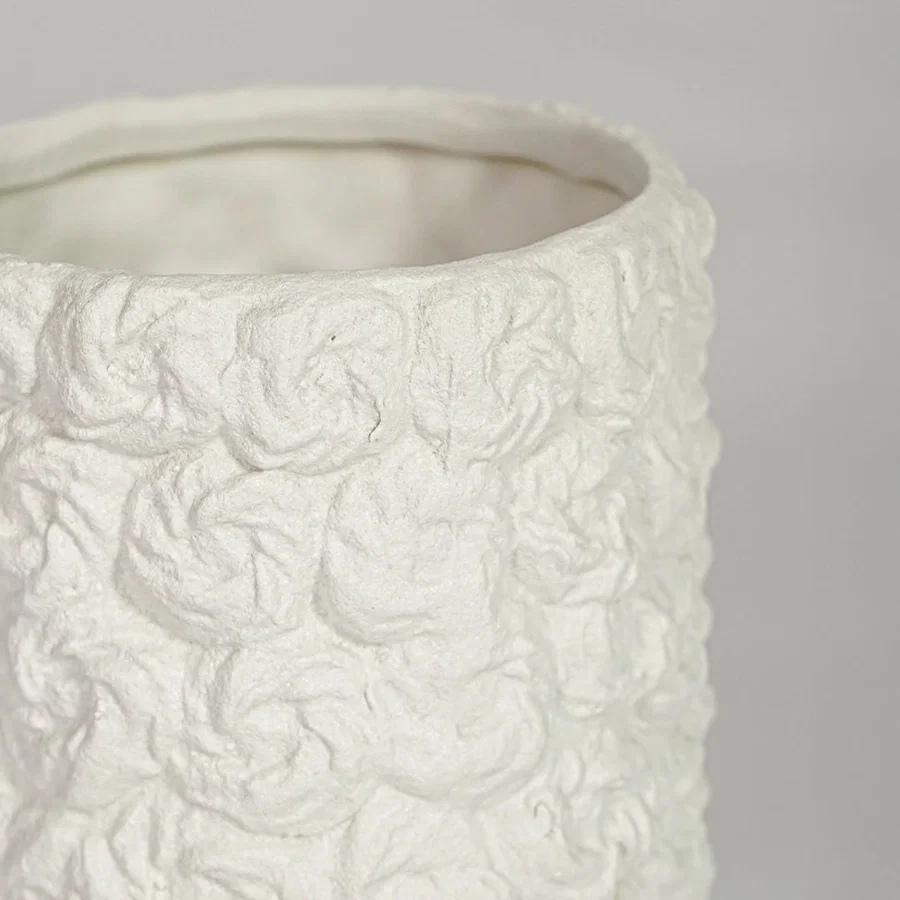 Closeup of white ceramic decorative vase with floral textured pattern showcasing premium craftsmanship and styling.