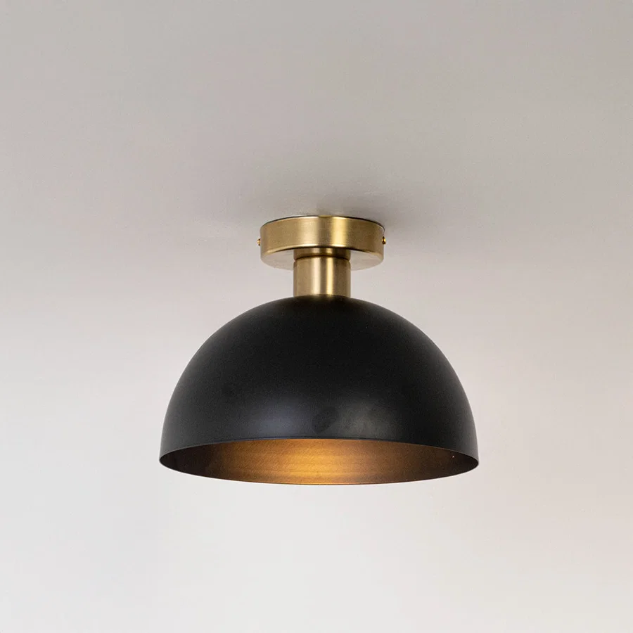 Modern black metal dome ceiling light with warm glow for contemporary bedroom and minimalist decor styling spaces.