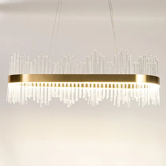 Gold metal chandelier with clear glass rods shown with lights on against a white background highlighting its bright elegant illumination.