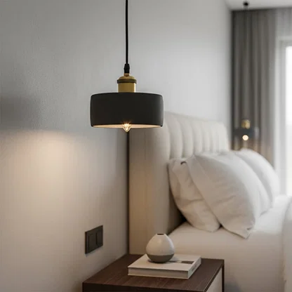 Black metal pendant light with gold details enhancing bedroom decor with modern sophistication.
