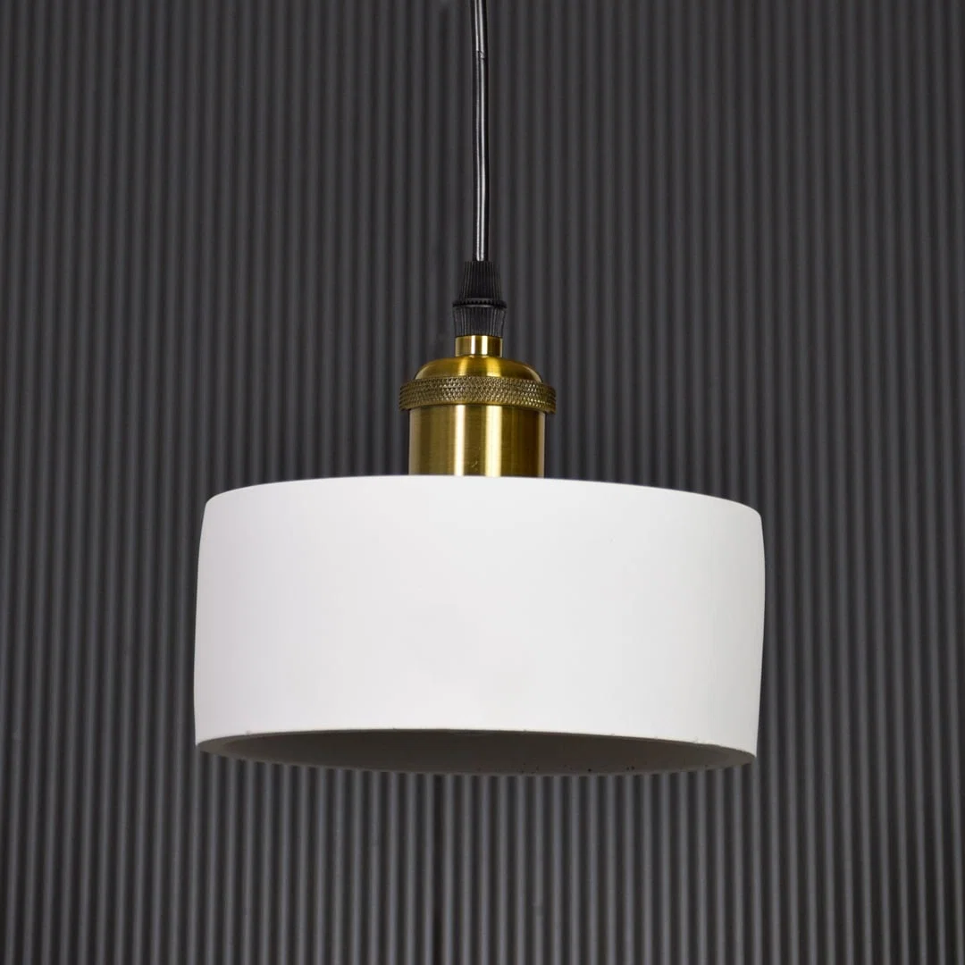 White metal pendant light with gold holder switched off on black background highlighting simple form and premium finish.