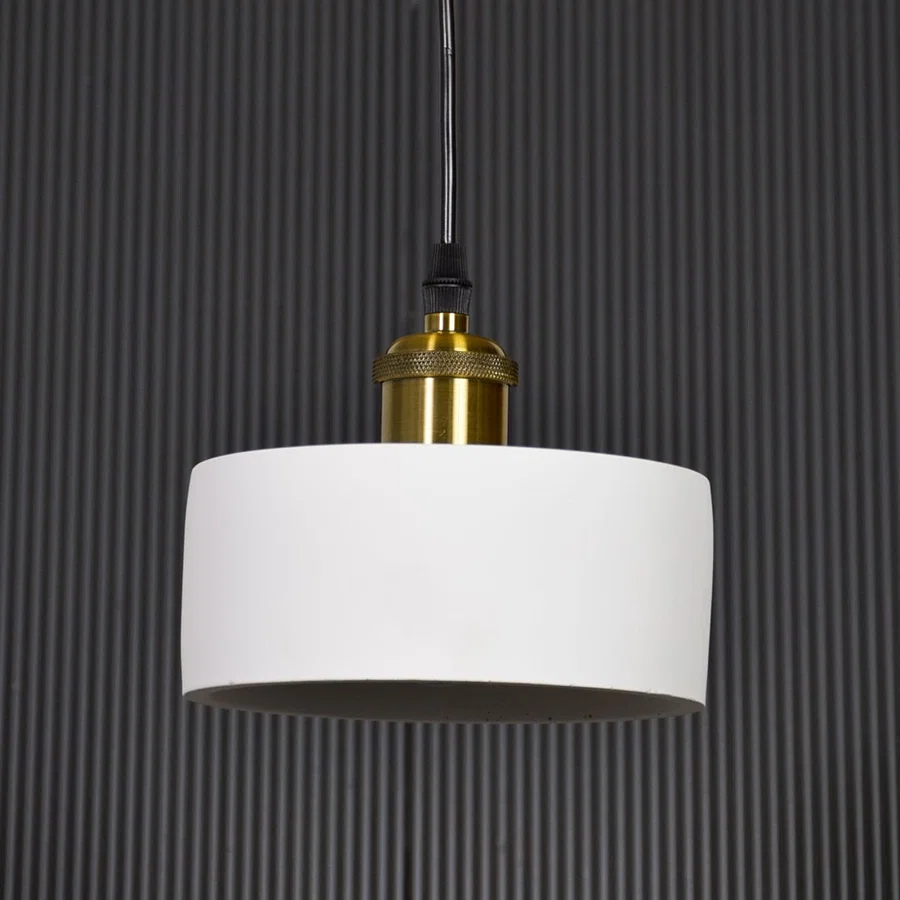 White metal pendant light with gold holder switched off on black background highlighting simple form and premium finish.