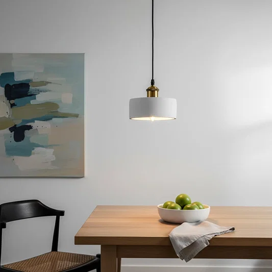 White metal pendant light above dining table adding minimalist elegance and soft ambient charm.