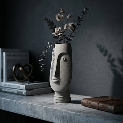 Grey ceramic face flower vase with dried stems placed on shelf for elegant modern home decor styling.