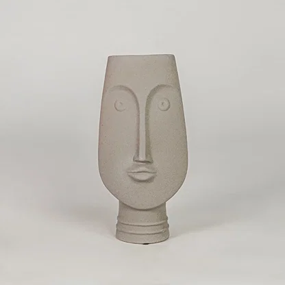 Beige face ceramic vase for modern shelf placement and elegant indoor home decor styling accent piece.
