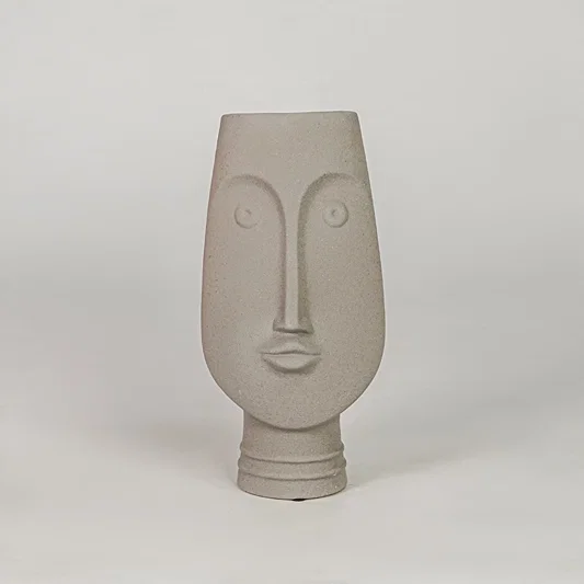 Beige face ceramic vase for modern shelf placement and elegant indoor home decor styling accent piece.