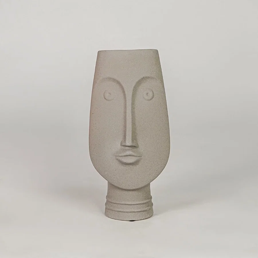 Beige face ceramic vase for modern shelf placement and elegant indoor home decor styling accent piece.