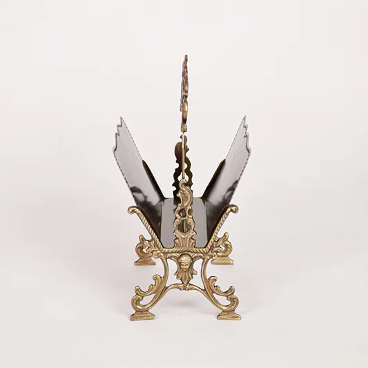 Antique metal napkin holder placed on white background presenting full structure raised sides decorative top handle and sturdy base for tabletop use.