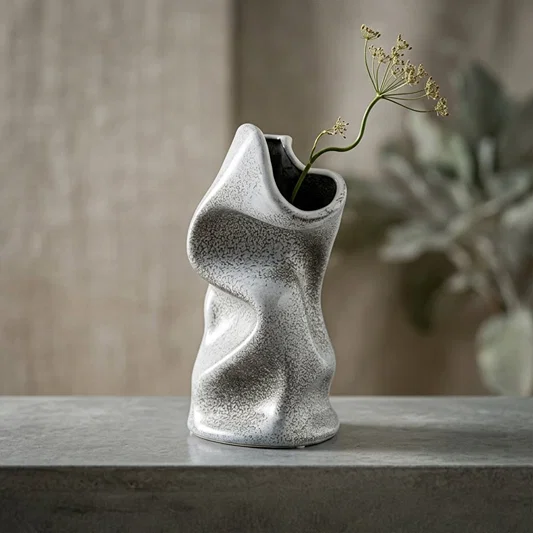 Lifestyle grey ceramic modern art flower vase placed on stone table with dried stem aesthetic home decor styling idea.