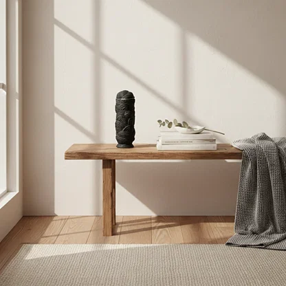 Black ceramic decorative sculpture styled on a wooden bench creating an elegant focal point in modern interiors.