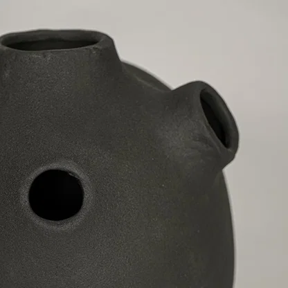 Closeup of black ceramic vase with matte textured finish for elegant tabletop and shelf decor styling ideas.