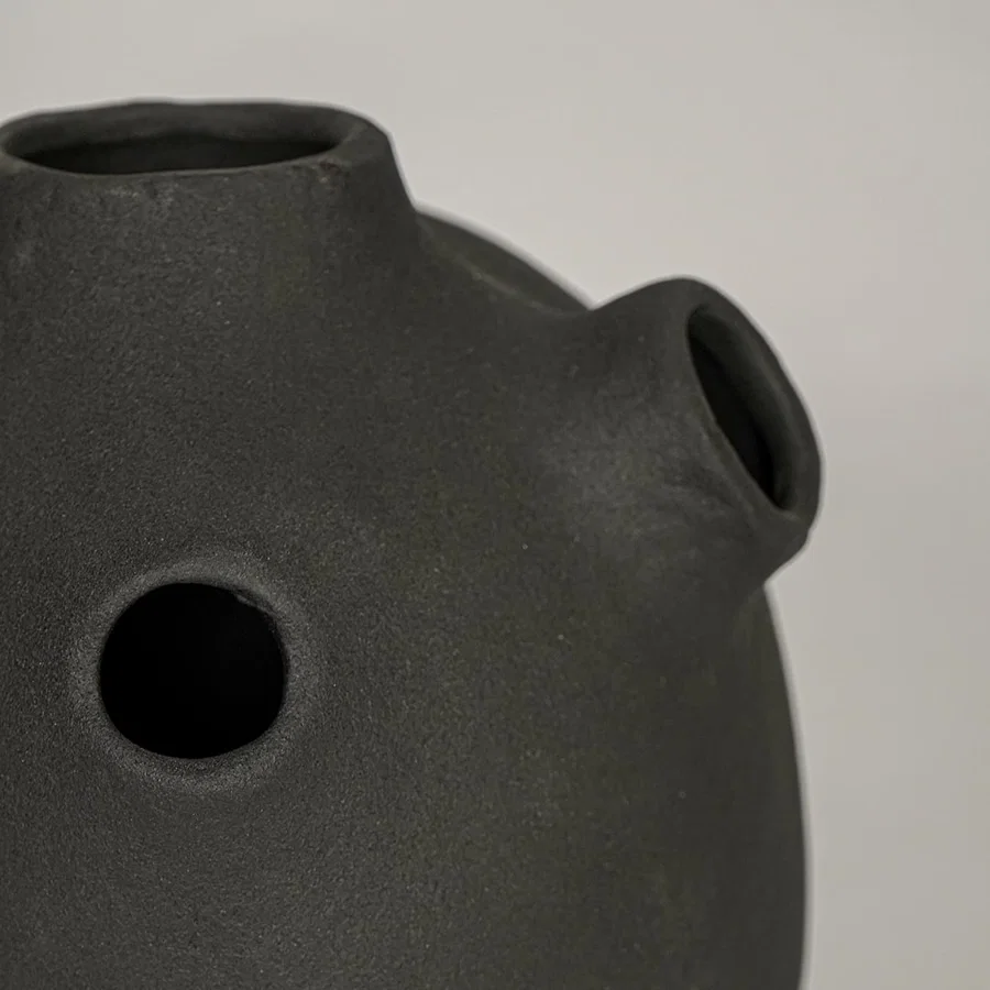 Closeup of black ceramic vase with matte textured finish for elegant tabletop and shelf decor styling ideas.