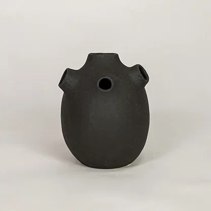 Black ceramic decorative vase with matte textured finish for modern tabletop shelf and console decor placement.