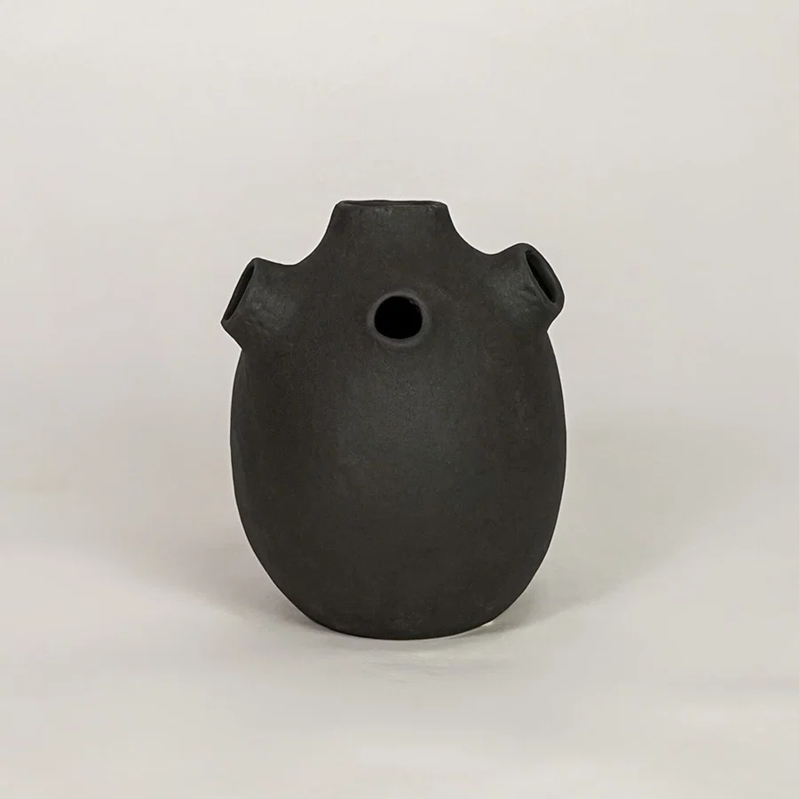 Black ceramic decorative vase with matte textured finish for modern tabletop shelf and console decor placement.