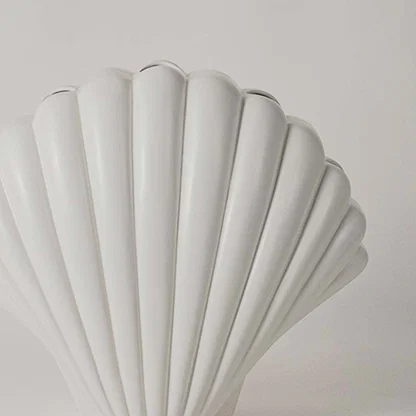 Closeup of white shell sculpture showing smooth ridged detailing and curved form for a refined coastal decor accent.